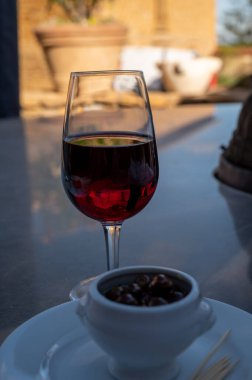 Tasting of red wine by old wine maker in Pierres Dores region with yellow stone houses on south of Beaujolais region France, wine appellation region