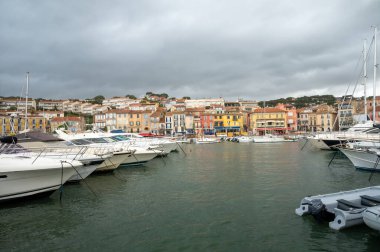 Fransa 'nın güneyinde nisan ayında yağışlı bir gün, Cassis, Provence, Fransa' da eski balıkçıların limanına tekne ve renkli binalarla bakmak