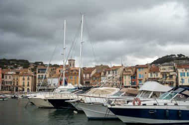 Fransa 'nın güneyinde nisan ayında yağışlı bir gün, Cassis, Provence, Fransa' da eski balıkçıların limanına tekne ve renkli binalarla bakmak