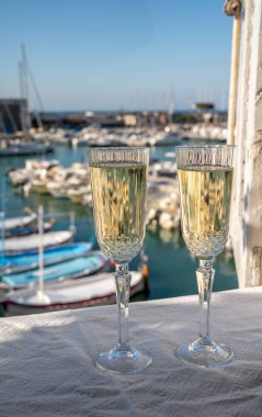 Yazın doğum günü kutlaması iki bardak Fransız şampanyası köpüklü şarap ve renkli balıkçı tekneleriyle Cassis, Provence, Fransa 'daki eski limanda.