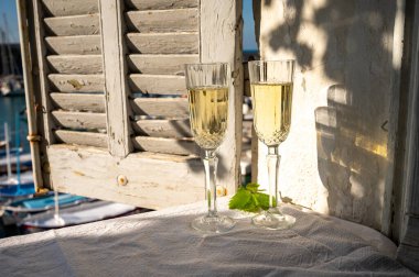 Yazın doğum günü kutlaması iki bardak Fransız şampanyası köpüklü şarap ve renkli balıkçı tekneleriyle Cassis, Provence, Fransa 'daki eski limanda.