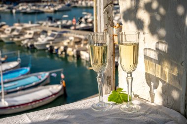 Yazın doğum günü kutlaması iki bardak Fransız şampanyası köpüklü şarap ve renkli balıkçı tekneleriyle Cassis, Provence, Fransa 'daki eski limanda.