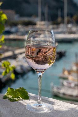 Açık terasta sunulan Rose Provencal şarabı Cassis, Provence, Fransa 'daki eski balıkçıların limanında renkli teknelerle servis ediliyor.