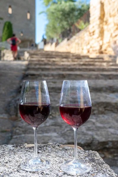 Tasting of red wine by old wine maker in Pierres Dores region with yellow stone houses on south of Beaujolais region France, wine appellation region