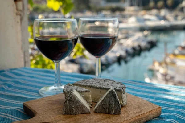 Kırmızı Provencal şarabı ve peynirli yaz partisi terasta eski balıkçıların limanı manzaralı Cassis, Provence, Fransa 'da renkli teknelerle