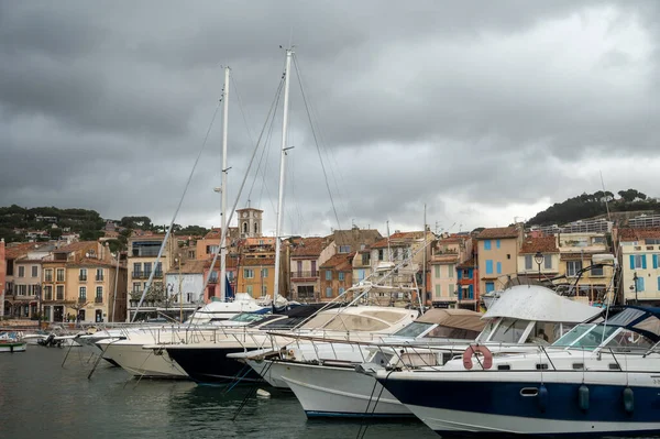 Fransa 'nın güneyinde nisan ayında yağışlı bir gün, Cassis, Provence, Fransa' da eski balıkçıların limanına tekne ve renkli binalarla bakmak