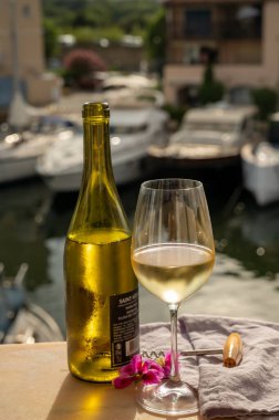 Port Grimaud 'un yat limanında manzaralı soğuk beyaz şarap içmek, Fransa' nın Provence şehrinde Fransız Rivierası 'nda yaz tatili