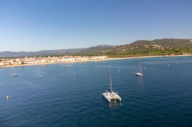Aerial view on blue water of Gulf of Saint-Tropez, sail boats, houses of Port Grimaud and Port Cogolin, summer vacation in Provence, France
