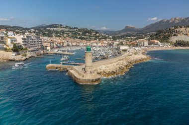Kumsalda panoramik hava manzarası, mavi deniz, uçurumlar, evler, sokaklar ve Cassis, Provence, Fransa 'da deniz feneri olan eski balıkçıların limanı bulutlu bir günde