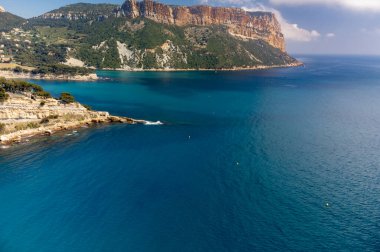 Kumsalda panoramik hava manzarası, mavi deniz, uçurumlar, evler, sokaklar ve Cassis, Provence, Fransa 'da deniz feneri olan eski balıkçıların limanı bulutlu bir günde