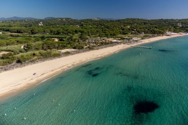 Saint-Tropez yakınlarındaki efsanevi Pampelonne plajı ve mavi deniz manzarası Fransız Rivierası 'nın beyaz kumlu sahillerinde yaz tatili.