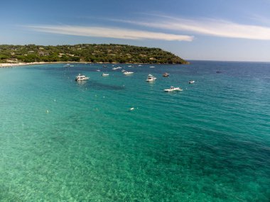 Saint-Tropez yakınlarındaki efsanevi Pampelonne plajı ve mavi deniz manzarası Fransız Rivierası 'nın beyaz kumlu sahillerinde yaz tatili.