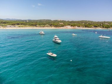 Saint-Tropez yakınlarındaki efsanevi Pampelonne plajı ve mavi deniz manzarası Fransız Rivierası 'nın beyaz kumlu sahillerinde yaz tatili.