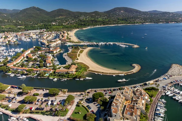 Aerial view on blue water of Gulf of Saint-Tropez, sail boats, houses of Port Grimaud and Port Cogolin, summer vacation in Provence, France
