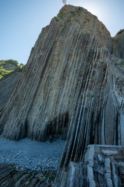 Zumaia 'nın Atlantik kıyısındaki alçak gelgitte, İspanya' nın Bask Bölgesi 'nde dik eğimli sinek jeolojik oluşumuna bakın.