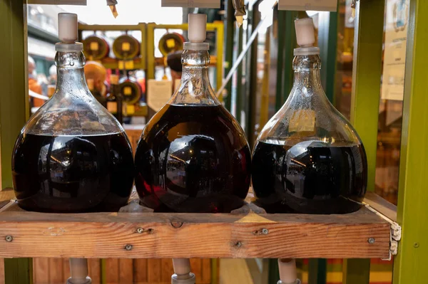 Big bottles with white and red wine Austrian vinegar made from local grapes on market in Vienna, Austria, close up