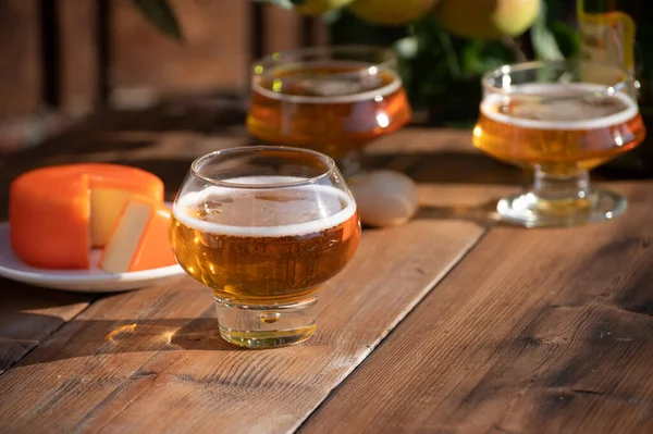 Food and drink pairing, apple cider in glasses produced on organic farm from bio apples in Normandy, France and farmers cheddar cheese from England