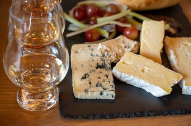 Pairing of scotch whiskies and farmers scottish cheeses cheddar, stilton, blue cheese, brie, tasting of whiskey and cheese in Edinburgh, UK