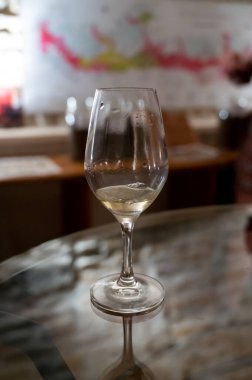 Wine tasting in underground cellars caves of French wine domain in Puligny-Motrachet village, Burgundy, France with map of Burgundy wine appelations and soils on background.