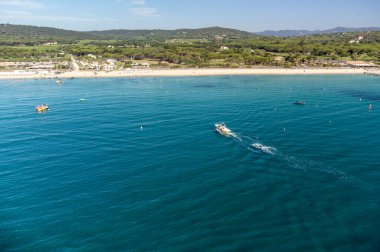 Saint-Tropez yakınlarındaki efsanevi Pampelonne plajı ve mavi deniz manzarası Fransız Rivierası 'nın beyaz kumlu sahillerinde yaz tatili.