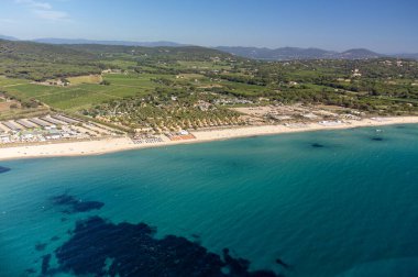 Saint-Tropez yakınlarındaki efsanevi Pampelonne plajı ve mavi deniz manzarası Fransız Rivierası 'nın beyaz kumlu sahillerinde yaz tatili.