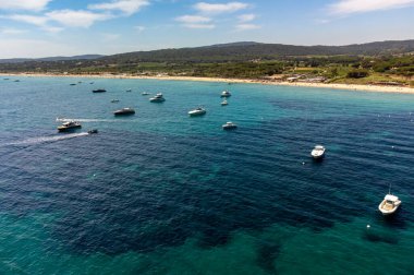Saint-Tropez yakınlarındaki efsanevi Pampelonne plajı ve mavi deniz manzarası Fransız Rivierası 'nın beyaz kumlu sahillerinde yaz tatili.