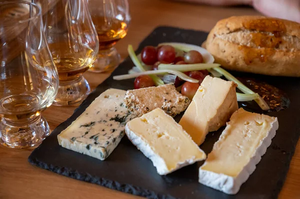 Pairing of scotch whiskies and farmers scottish cheeses cheddar, stilton, blue cheese, brie, tasting of whiskey and cheese in Edinburgh, UK