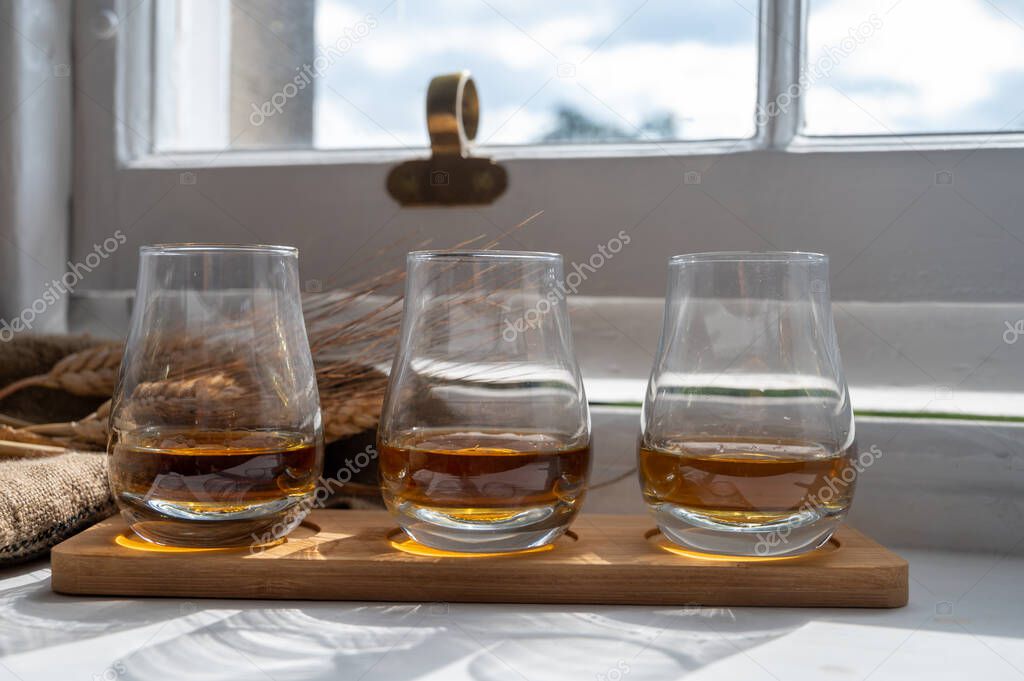 Flight of single malt and blended scotch whisky served on old wooden window sill in Scottisch house in Edinburgh, Scotland, UK, dram of whiskey