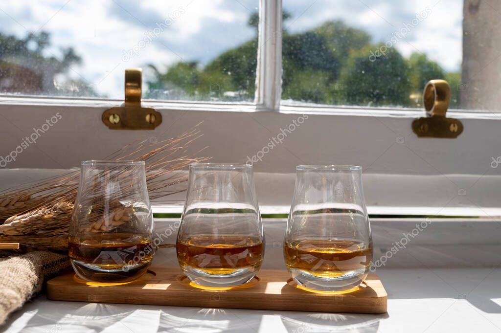 Flight of single malt and blended scotch whisky served on old wooden window sill in Scottisch house in Edinburgh, Scotland, UK, dram of whiskey