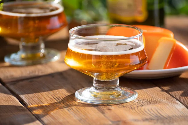 Food and drink pairing, apple cider in glasses produced on organic farm from bio apples in Normandy, France and farmers cheddar cheese from England