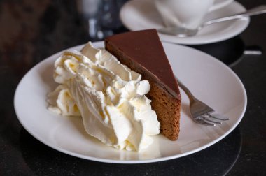 Avusturya kaynaklı kayısı reçelli ünlü Sachertorte çikolatalı pastası. Viyana 'daki eski klasik kafe restoranında kremayla servis ediliyor.