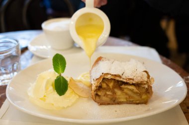 Pouring of txakoli or chacol slightly sparkling very dry white wine produced in Spanish Basque Country, served outdoor with view on Bay of Biscay, Atlantic Ocean