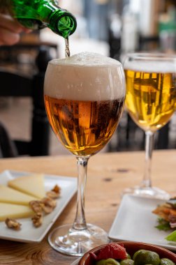 İspanyol açık hava kafesinde soğuk birayla öğle yemeği, yeşil zeytinli tapas kasesi ve fındıklı İspanyol peynirli manchego, Malaga, Endülüs...
