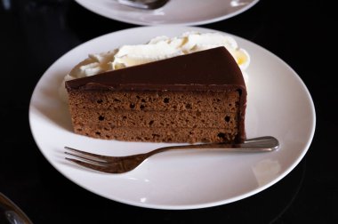 Avusturya kaynaklı kayısı reçelli ünlü Sachertorte çikolatalı pastası. Viyana 'daki eski klasik kafe restoranında kremayla servis ediliyor.