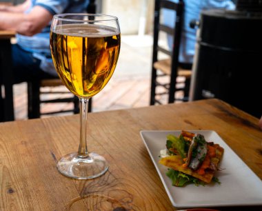 Fresh draught lager beer is glass served in outdoor cafe close up