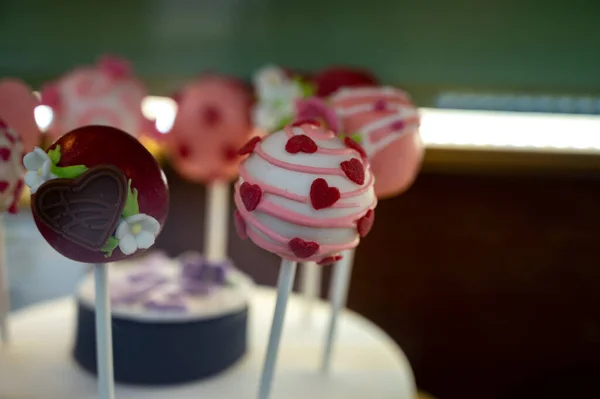 Food styling in bakery, wedding or happy valentine colorful lollypop candies decorated with chocolate hearts and flowers