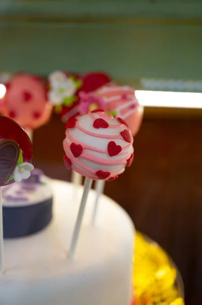 Food styling in bakery, wedding or happy valentine colorful lollypop candies decorated with chocolate hearts and flowers