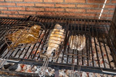 Eski mangal kömürü parillas beyaz balık levrek ve turbot, küçük balıkçı köyü Getaria, Bask Ülkesi, İspanya 'daki binaların dışına inşa