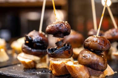 Bask Ülkesi ve Navarre 'ın barlarında tipik atıştırmalıklar, pinkhos veya pinktolar, malzemelerin içeriğinin veya karışımının konduğu küçük dilimler, San Sebastian, İspanya,