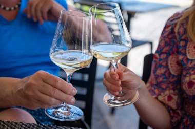 Pouring of txakoli or chacol slightly sparkling very dry white wine produced in Spanish Basque Country, served outdoor with view on Bay of Biscay, Atlantic Ocean