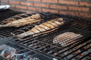 Eski mangal kömürü parillas beyaz balık levrek ve turbot, küçük balıkçı köyü Getaria, Bask Ülkesi, İspanya 'daki binaların dışına inşa