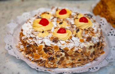 Kremalı ve kavrulmuş badem fıstıklı kek San Sebastian City, Bask Bölgesi, İspanya 'da zanaat fırınında sergileniyor.