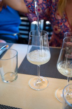 Pouring of txakoli or chacol slightly sparkling very dry white wine produced in Spanish Basque Country, served outdoor with view on Bay of Biscay, Atlantic Ocean
