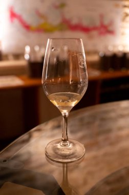 Wine tasting in underground cellars caves of French wine domain in Puligny-Motrachet village, Burgundy, France with map of Burgundy wine appelations and soils on background.