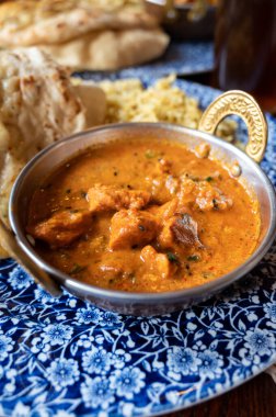Indian style food, chiken tikka masala curry dish served with rice and garlic bread naan, close up