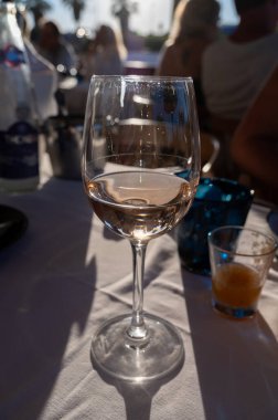 Fransız gurme restoranında gün batımında akşam yemeği. Port Grimaud 'da soğuk gül şarabı, Fransız Riviera, Fransa' da yaz tatili.