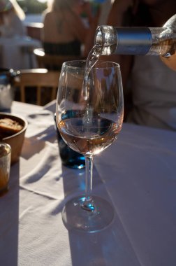 Fransız gurme restoranında gün batımında akşam yemeği. Port Grimaud 'da soğuk gül şarabı, Fransız Riviera, Fransa' da yaz tatili.