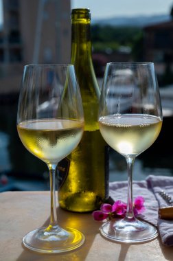 Port Grimaud 'un yat limanında manzaralı soğuk beyaz şarap içmek, Fransa' nın Provence şehrinde Fransız Rivierası 'nda yaz tatili