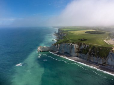 Etretat 'taki Porte d' Aval kemeri yakınlarındaki tebeşir kayalıklarındaki Aerian manzarası yeşil çayırlar ve kıyı şeridi ve Atlantik Okyanusu 'nun mavi suyu, Normandiya, Fransa. Turistler için tatil yeri.