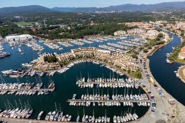Aerial view on blue water of Gulf of Saint-Tropez, sail boats, houses of Port Grimaud and Port Cogolin, summer vacation in Provence, France